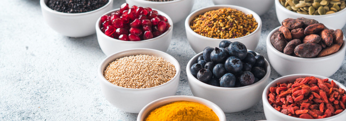 Various superfoods in bowl on gray background