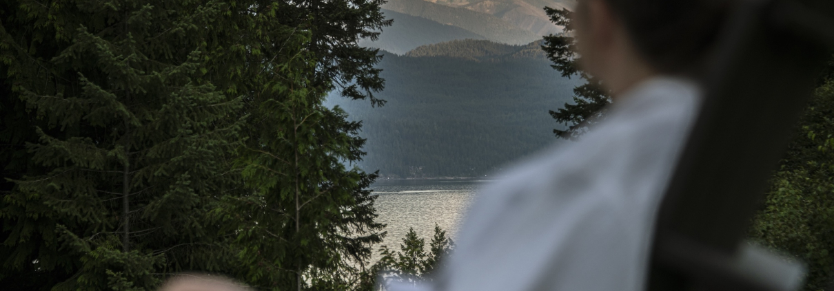 Guest in Robe Relaxing at Mountain Trek Health Reset Retreat overlooking Mountains and lake