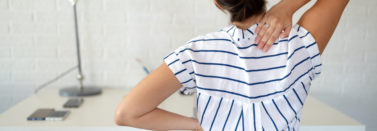 Overworked woman with back pain in office sitting on chair with bad posture