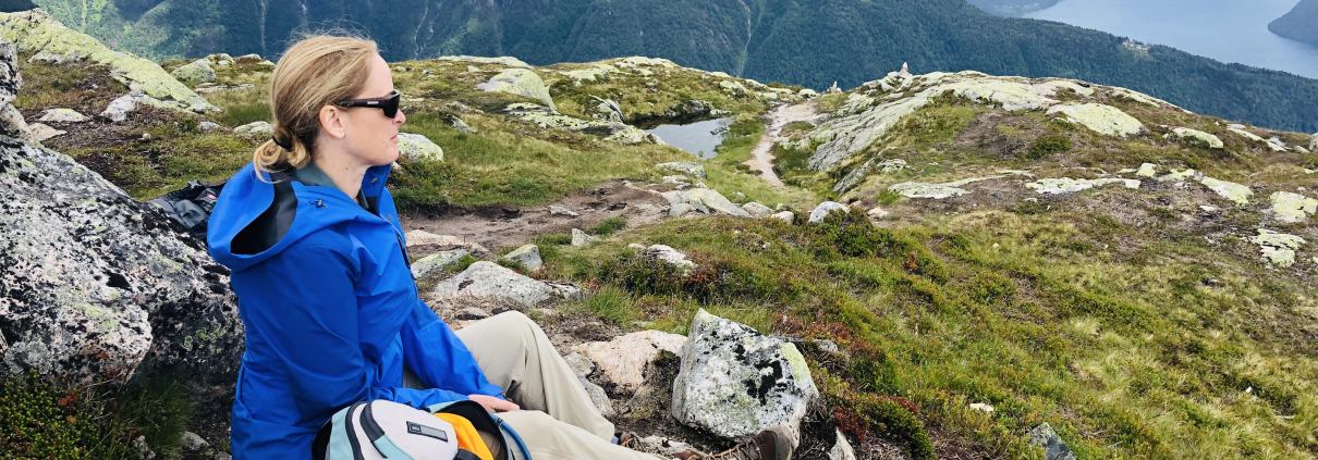 Woman at top of mountain stopping to enjoy the views and rest